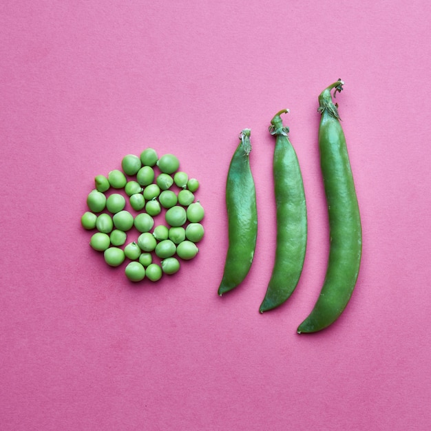 Photo creative composition from grains of green peas in the form of a circle and full of closed pods
