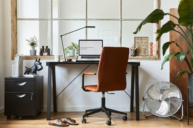 Creative composition of modern masculine home office interior\
design with black industrial desk, brown leather armchair, laptop\
and stylish personal accessories. template.