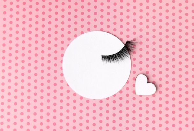 Photo creative composition with eyelashes on pink background