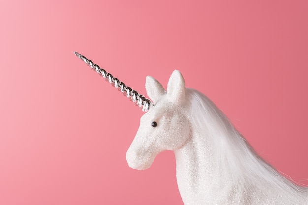 Creative composition with glitter unicorn on pink background