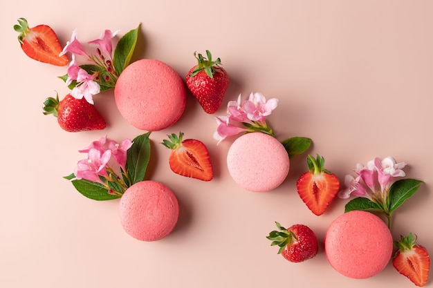 Creative composition with macaroons strawberries flowers