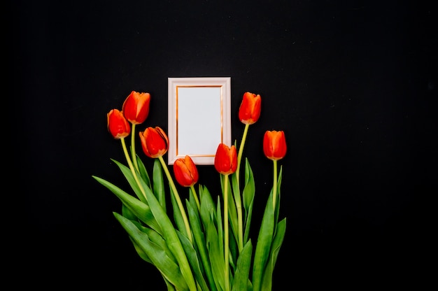 Creative composition with photo frame mockup, red tulips 