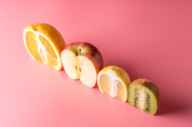 Фото Креативная композиция с нарезанными фруктами на розовом фоне