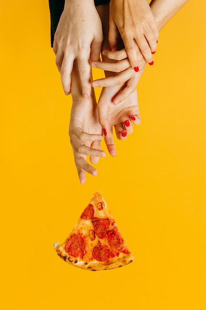 Creative concept advertising fast food hands reach for a piece\
of pizza