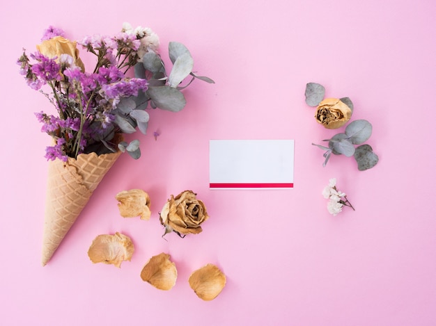 Creative concept flat lay of dry flower and card on pink background with copy space