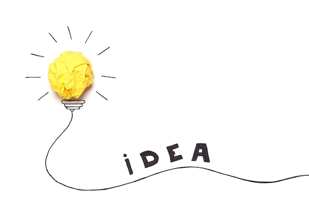 Creative concept idea painted light bulb with a crumpled paper yellow ball