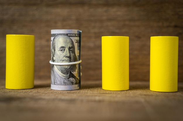 Creative concept a roll of dollar banknote and yellow wooden cube.