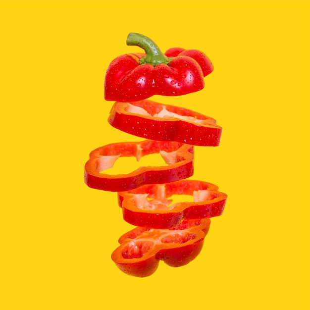 Creative concept with Flying red capsicum Sliced floating bell pepper on an orange background
