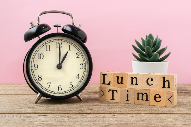 Foto concetto creativo parola ora di pranzo sul blocco di legno.