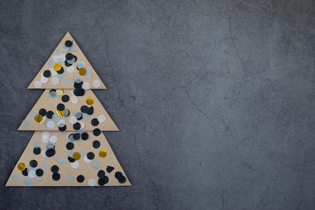 A creative craft paper christmas tree on a dark gray background. Waiting for the holiday concept