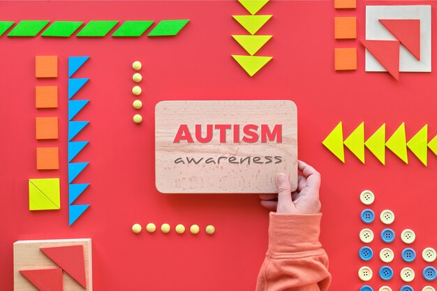 Creative design for Autism World Day on April 2. Hand hold wooden board with text World Autism Day