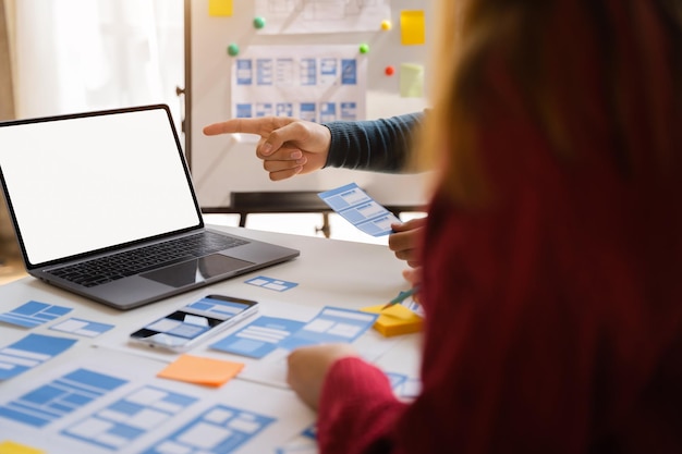 Foto il team di sviluppatori dell'agenzia di sviluppo digitale creativo fa il brainstorming sul proprio progetto con smartphone portatile e tablet digitale