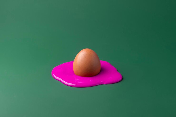 Photo creative easter concept brown chicken egg melts in purple paint on dark green background