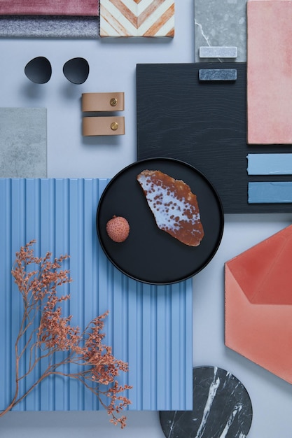 Composizione creativa piatta del moodboard di interior designer con campioni di tessuti e vernici pannelli e piastrelle lamellari blu tavolozza dei colori rosa nero blu e grigio chiaro spazio di copia modello