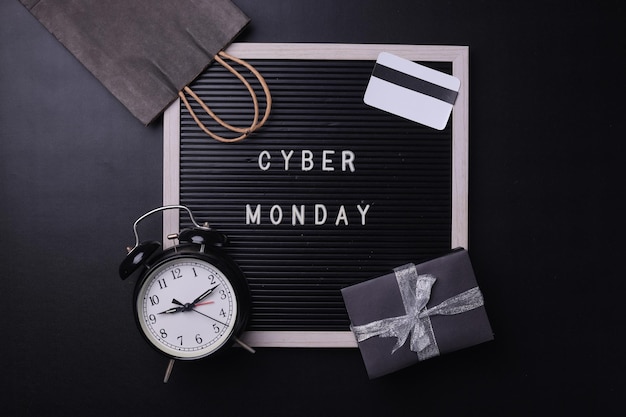 Foto composizione creativa della promozione a disposizione piatta testo di vendita del cyber monday a bordo con materiale per lo shopping