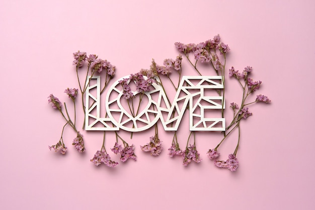 Creative flat lay of word love with natural plants.