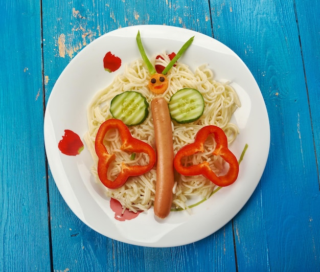 Creative food concept -  butterfly for kids  made of sausage and vegetables