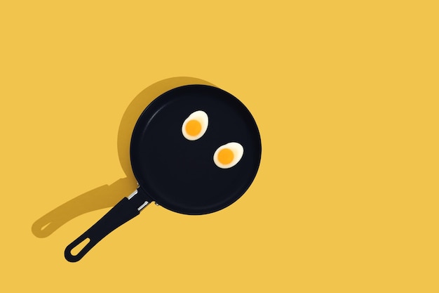 Creative food concept with gummy candy fried egg shaped on black frying pan over yellow background Morning breakfast top view Seamless pattern minimal style Flat lay Copy space