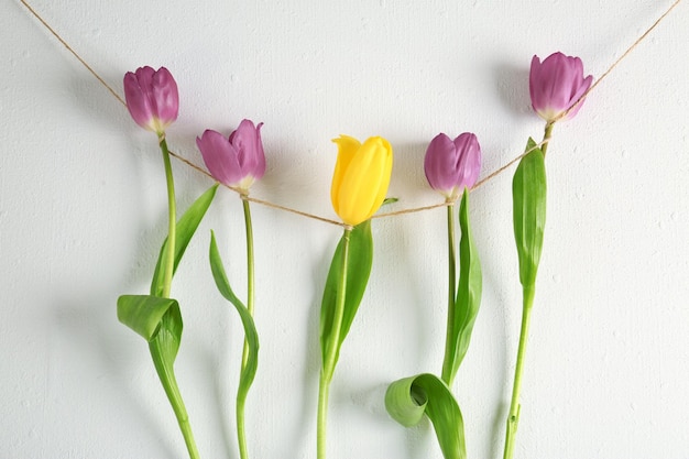 Creative garland with lilac tulips on white background