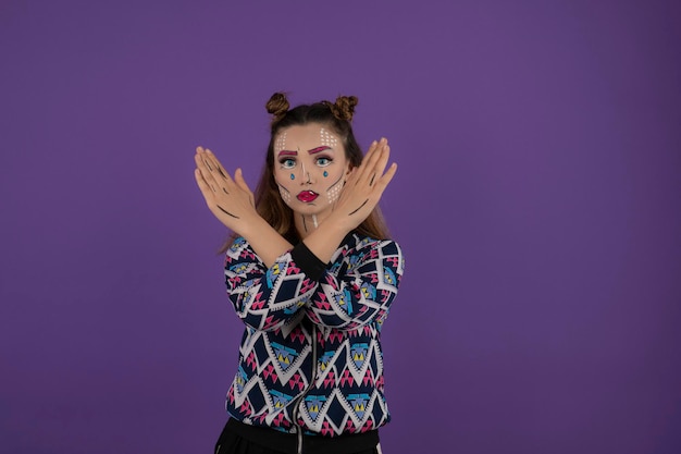 Creative girl with colorful makeup. young girl crossed her hands and looking at camera. High quality photo