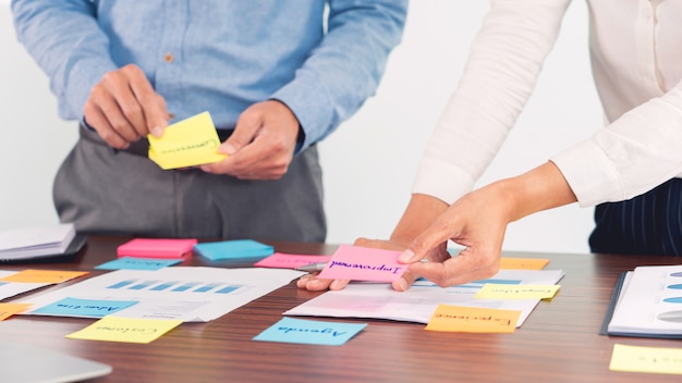 Creative group of business people brainstorming use sticky notes picking to share idea on table