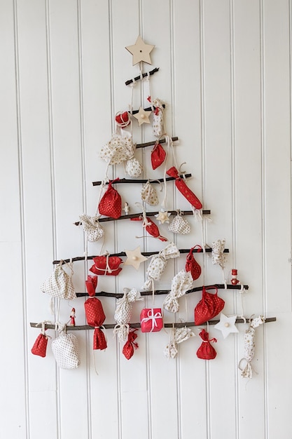 Creative handmade Christmas Tree advent calendar with gift boxes red on white plank wooden background