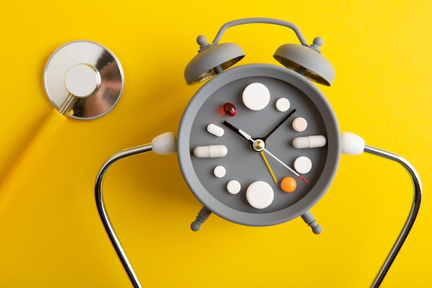 Creative healthcare and medicine concept clock with drugs and pills Right time for using medicines