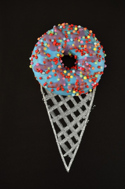 Creative image of a donut and a painted waffle cone on a black background