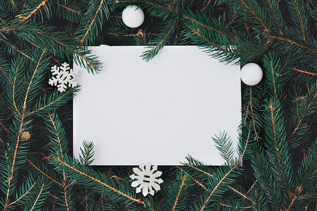 Layout creativo fatto di rami di albero di natale con nota di carta di carta. concetto di capodanno della natura.