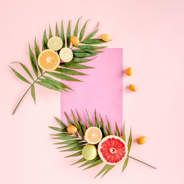 Creative layout made of paper and summer tropical fruits on pink background food concept flat lay to