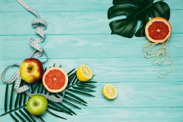 Creative layout made of summer tropical fruits and leaves. Flat lay. Fitness concept.