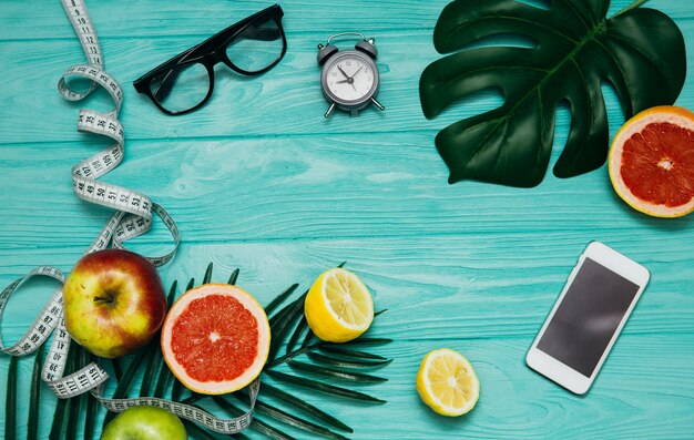 Creative layout made of summer tropical fruits and leaves. Flat lay. Fitness concept.