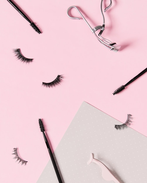 Foto layout creativo con accessori per il trucco su sfondo rosa pastello