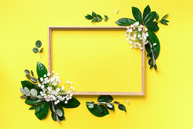 Photo creative layout with white flowers and copyspace over yellow background top view flat lay spring and summer concept