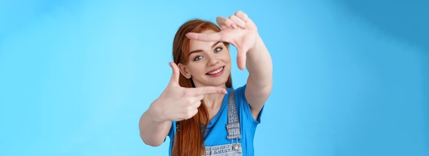 Creative lucky redhead female designer getting inspiration look through frame gesture picturing nice