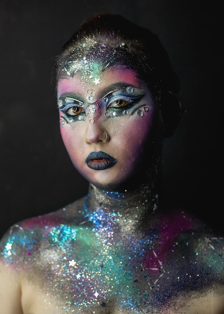 Creative makeup of a girl with rhinestones and piercing