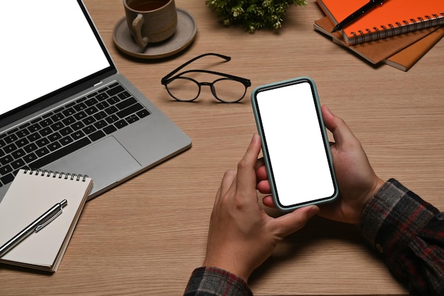 Creative man sitting at workplace and using smart phone