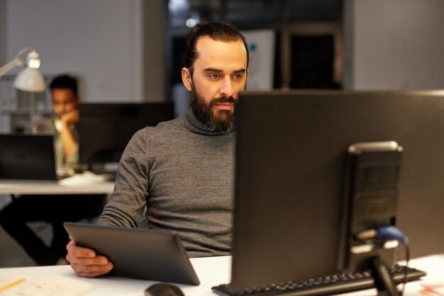 creative man with computer working late at office