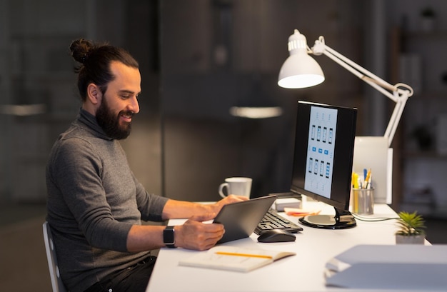 Foto uomo creativo con computer che lavora in ufficio notturno