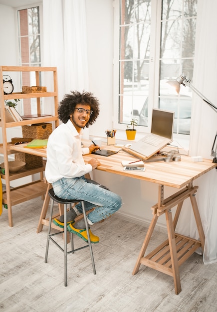 Creative man working with laptop at home office interior