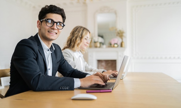 女性がラップトップ コンピューターを使用してオフィスで正装で働くクリエイティブ マネージャー パートナー
