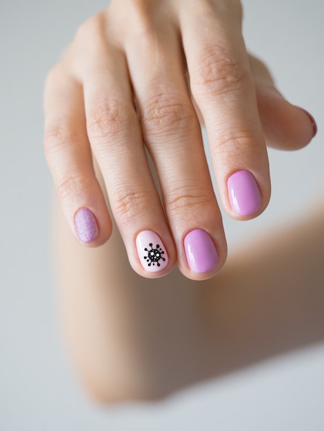 Creative manicure with painted coronavirus on the nails.