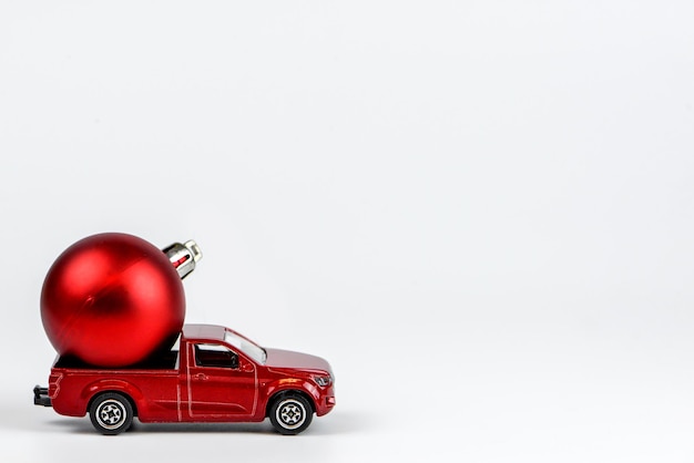 Creative Merry Christmas concept with red toy car with Christmas decorations on white background