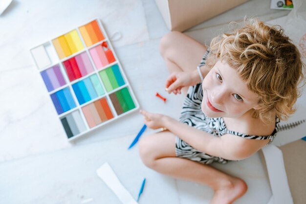 Foto disordine creativo nella stanza dei bambini bambina che gioca con la pasta di gioco vista superiore