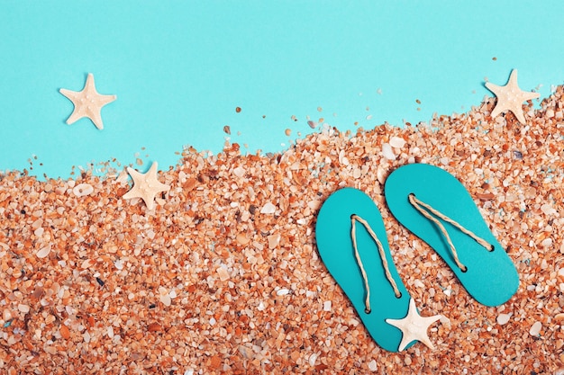Креативная минимальная концепция пляжа Летние каникулы с песчаными шлепанцами маленькие морские звезды