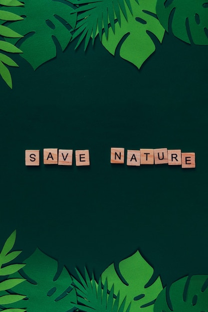 「SaveNature」の文字が付いた熱帯の葉で作られたクリエイティブなモックアップ。上からの眺め。自然の概念。