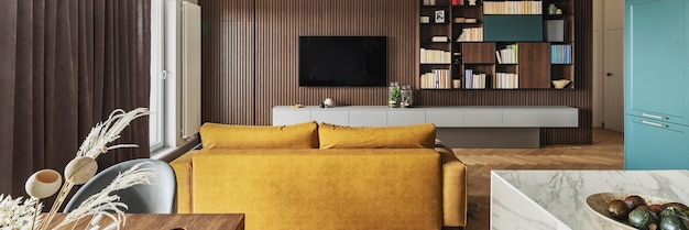 Креативный и современный винтажный дизайн интерьера гостиной с желтым диваном и ламельной стеной с телевизором и книжным шкафом Паркет в елочку с комодом Коричневая занавеска в окнах Шаблон