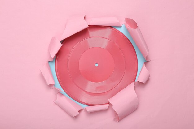 クリエイティブな音楽レイアウト ピンク ブルーの紙の破れた穴からピンクのビニール レコード パステル カラーのトレンド 新鮮なアイデア ミニマリズム コンセプト アート フラット レイアウト トップ ビュー