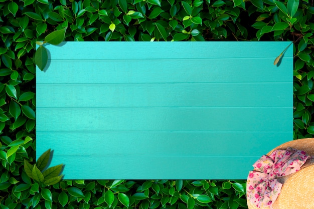 Creative nature layout made of tropical leaves and flowers With Blue wood grain flat lay. 