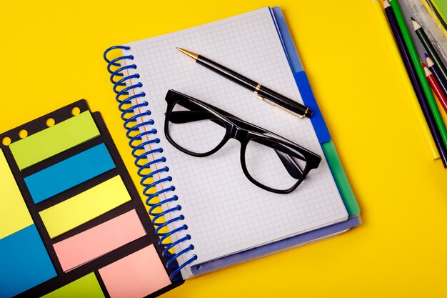 Creative office concept with colorful supplies on yellow table